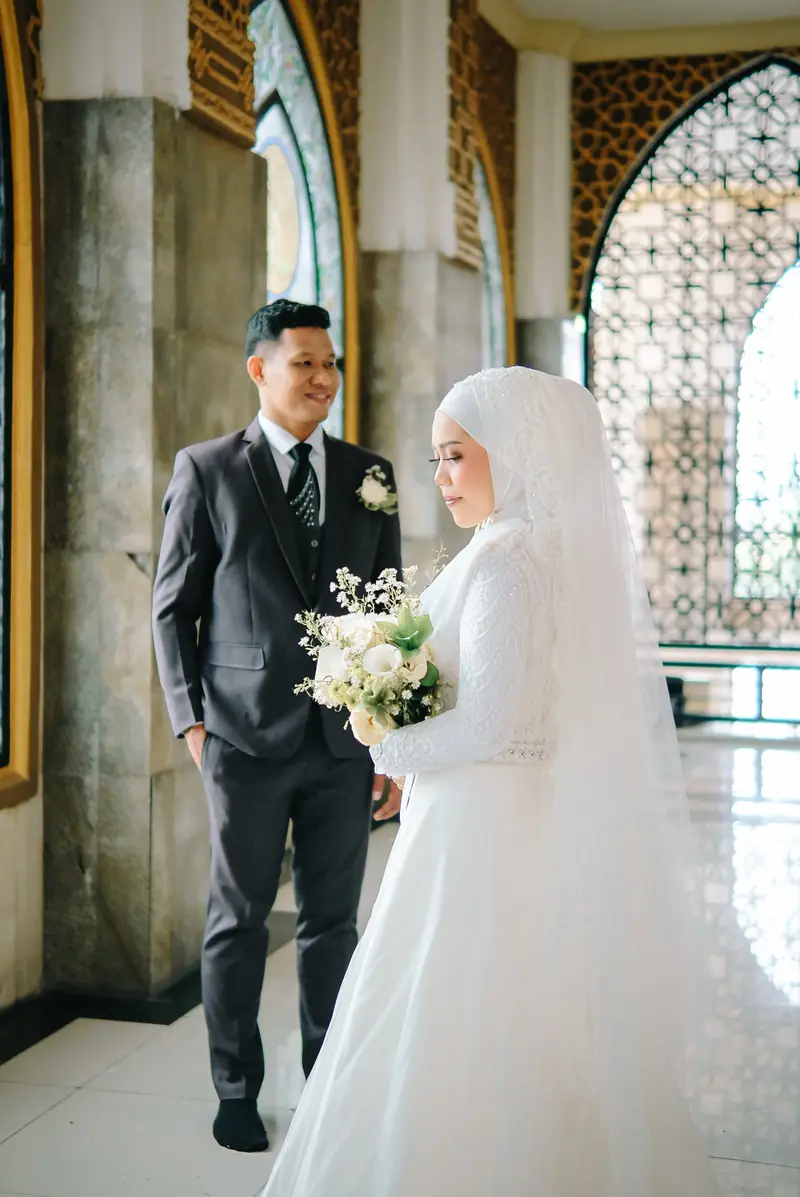 Illuxio Photography, fotografer wedding Klaten: pasangan pengantin berpose di lorong masjid
